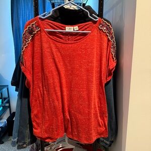 Cato’s Red Blouse with Shoulder Embellishments